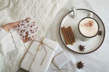 female hand holds a snowflake, coffee with chocolate