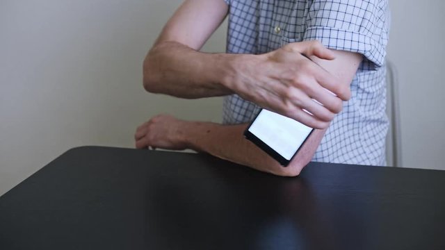 A man hands brings to the hand the smartphone for measuring glucose in the blood