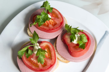 sandwich of bread, boiled sausage, tomato and parsley, appetizer with sausage and vegetables