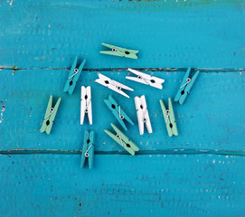 Multi-colored clothespins on a blue wooden background in the center.