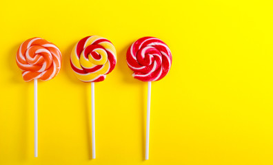 Colorful swirl lollypops  over yellow paper