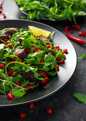 Spicy crispy duck salad with pomegranate seeds, lime and wild green rucola