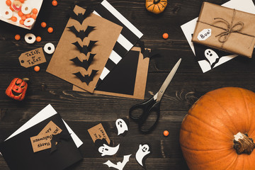 Halloween pumpkin, sweets, halloween cards and decoration made of craft paper on the wooden table