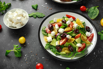 Fresh Greek salad with cucumber, cherry tomato, lettuce, red onion, feta cheese and black olives. Healthy food