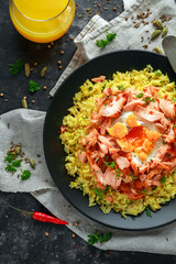 Traditional Indian-English kedgeree breakfast: basmati rice with egg benedict and hot smoked sweet chilli salmon.