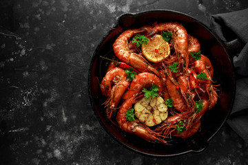 Tiger prawns fried in butter with, lemon juice, garlic and white wine served in cast iron skillet with parsley