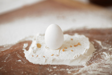 chicken egg on the table. Preparation of pasta from eco-home products. Flour is scattered around