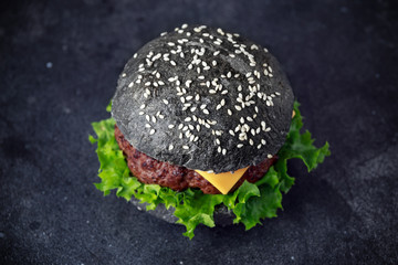Black Burger with Cheese, Beef and Green salad leaves. Homemade cheeseburger
