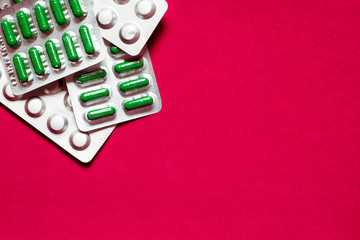 Medicine pills or capsules on red background