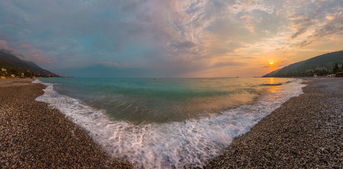 The picturesque sea at sunset. Sunset on the Black Sea with the sun. Georgia, Abkhazia. Colorful sunset with waves.