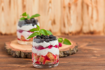 Trifle close up photography with fresh multi layered dessert with dairy and ripe raspberries and...