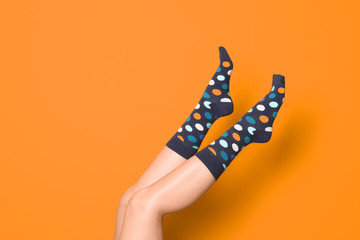 Woman wearing bright socks on color background