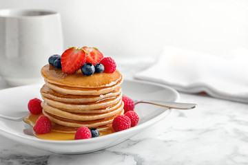Tasty pancakes with berries and honey on plate © New Africa