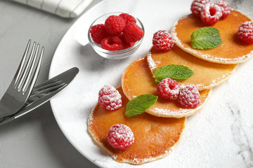 Tasty pancakes with berries and mint on plate