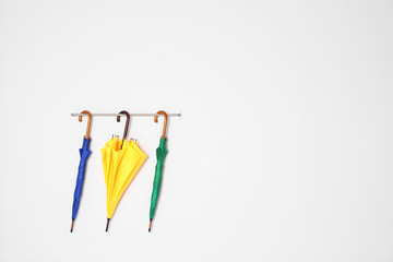 Beautiful bright umbrellas hanging on wall with space for design