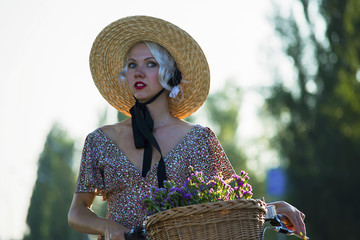 pretty girl is riding a bicycle in a city in the summer