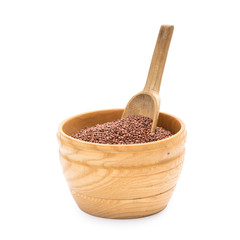 Red quinoa seeds in a wooden bowl with a spoon seen from the side and isolated on white background