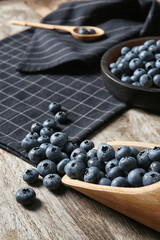 Dishware with juicy and fresh blueberries on wooden table