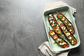 Baking dish with fried eggplant slices on grey background, top view. Space for text