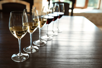Glasses of white and red wines on wooden table