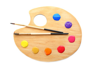 Palette with paints and brushes on white background, top view