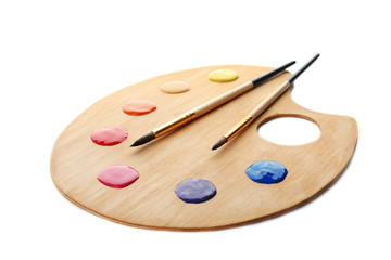 Naklejka premium Palette with paints and brushes on white background