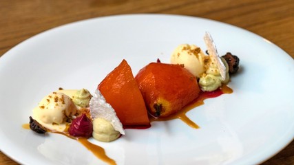 Baked pear with vanilla ice cream close-up on a plate. Cafe GRUSHA, Krasnaya Polyana