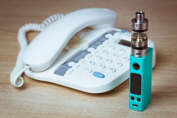 Ecig and telephone on wooden background