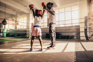 Coach raising the hand of a boxing kid in appreciation