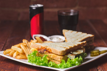 Club sandwich served with french fries and soda