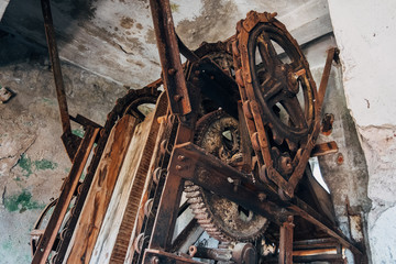 Old rusty gears and chain drive of broken conveyor mechanism