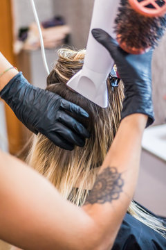 The hairdresser dries the hair with a hair dryer client, after washing the head with shampoo, before spreading nutrients on the hair, botox hair