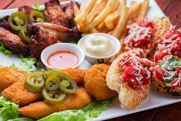 Big and tasty combo of nuggets, french fries, fried chicken legs and canape