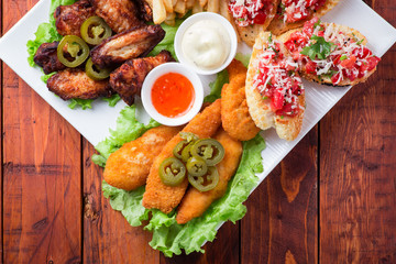 Big and tasty combo of nuggets, french fries, fried chicken legs and canape
