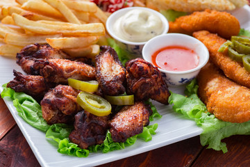 Big and tasty combo of nuggets, french fries, fried chicken legs and canape