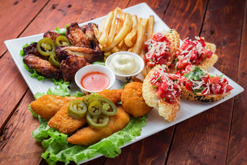 Big and tasty combo of nuggets, french fries, fried chicken legs and canape