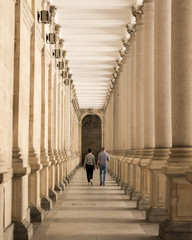 man and woman walking through colonnade