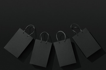Black shopping bags on black background, Black Friday sale flat lay