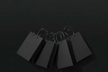 Black shopping bags on black background, Black Friday sale flat lay