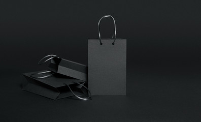 Black shopping bags on black background, black friday sale template