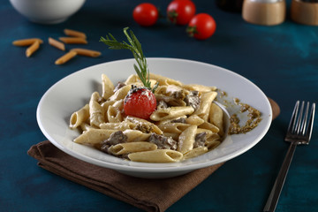 penne with sauce on a wooden background