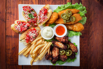 Big and tasty combo of nuggets, french fries, fried chicken legs and canape