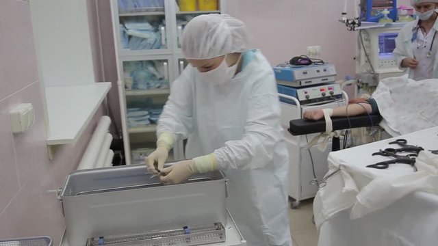 A team of nurses prepares surgical instruments for sterilization