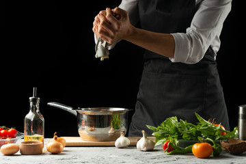 Preparation of tomato sauce by the hands of the chef, steps the process in the kitchen on a black background copy the text of the recipe.The concept of cooking food