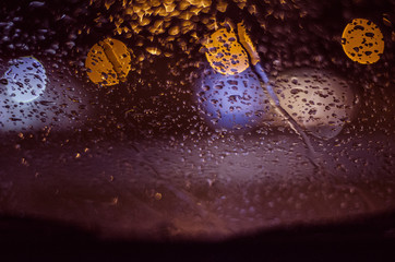  Lights  blue and yellow through a glass wet from the rain
