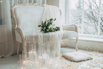 Beautiful wedding bouquet of white roses and orchids on an old classic white sofa.