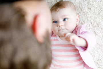Happy proud young father having fun with newborn baby daughter, family portrait together. Dad with baby girl, love. New born child looking on dad. Bonding, family, new life.