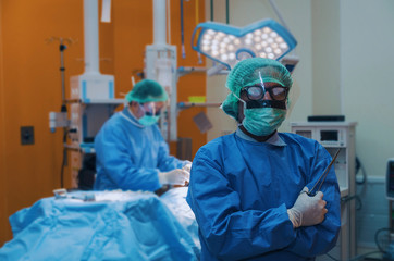 surgeon crossing arms after work for rescue patient in operation room at hospital, health care cancer, emergency case, surgery, medical technology, disease treatment concept, blue color tone