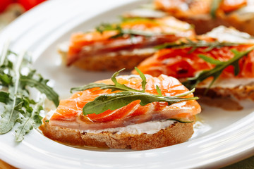 Whole grain bread with avocado paste and salmon decorated with arugula