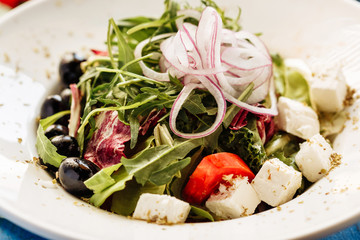Salad with arugula, tomato, cheese and red onion. Close view for restaurant menu